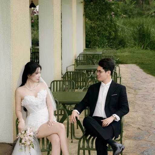 The couple sits on chairs on a Đà Lạt café veranda.