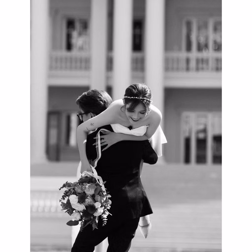 Black-and-white photograph of the bride and groom embracing at Nhà thờ Don Bosco