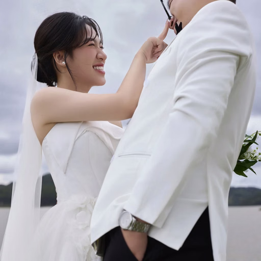 The bride smiles and touches the groom's face at Cây Thông Cô Đơn, Đà Lạt