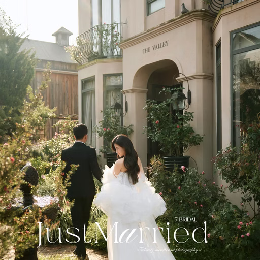 The couple walks away through a flower garden beside a building, with Just Married lettering at The Nest, Đà Lạt