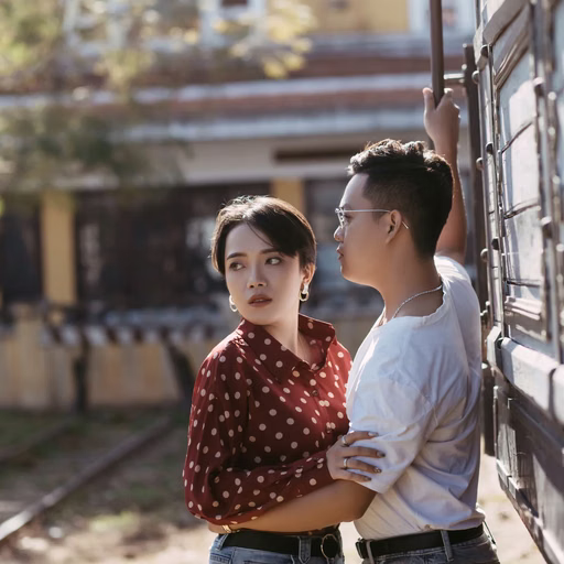 The couple embracing beside a vintage carriage at Ga Đà Lạt.