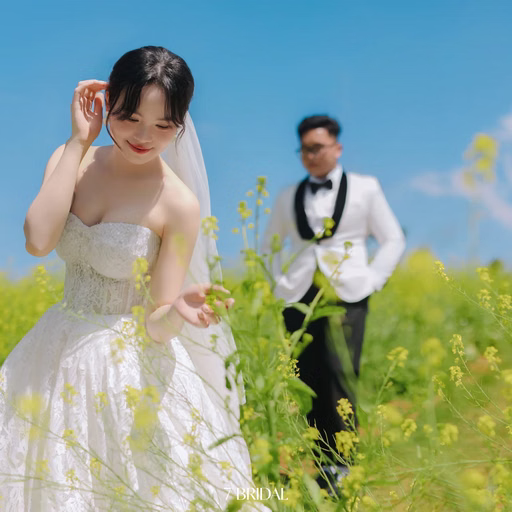 Cô dâu mỉm cười đưa tay lên tóc giữa đồng hoa vàng tại Hoa Trong Rừng, Đà Lạt