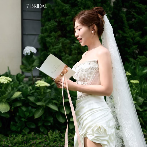 The bride reading a message to the groom before garden hydrangeas.