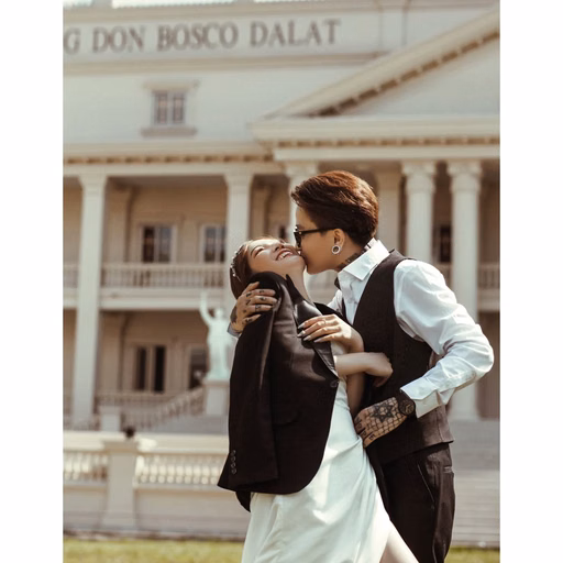 The groom kissing the bride’s hand before Nhà thờ Don Bosco