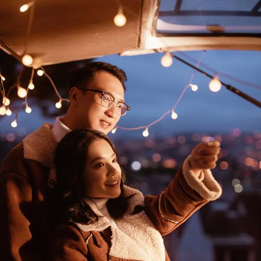 The couple embraces beside a camper van door and looks into the distance.