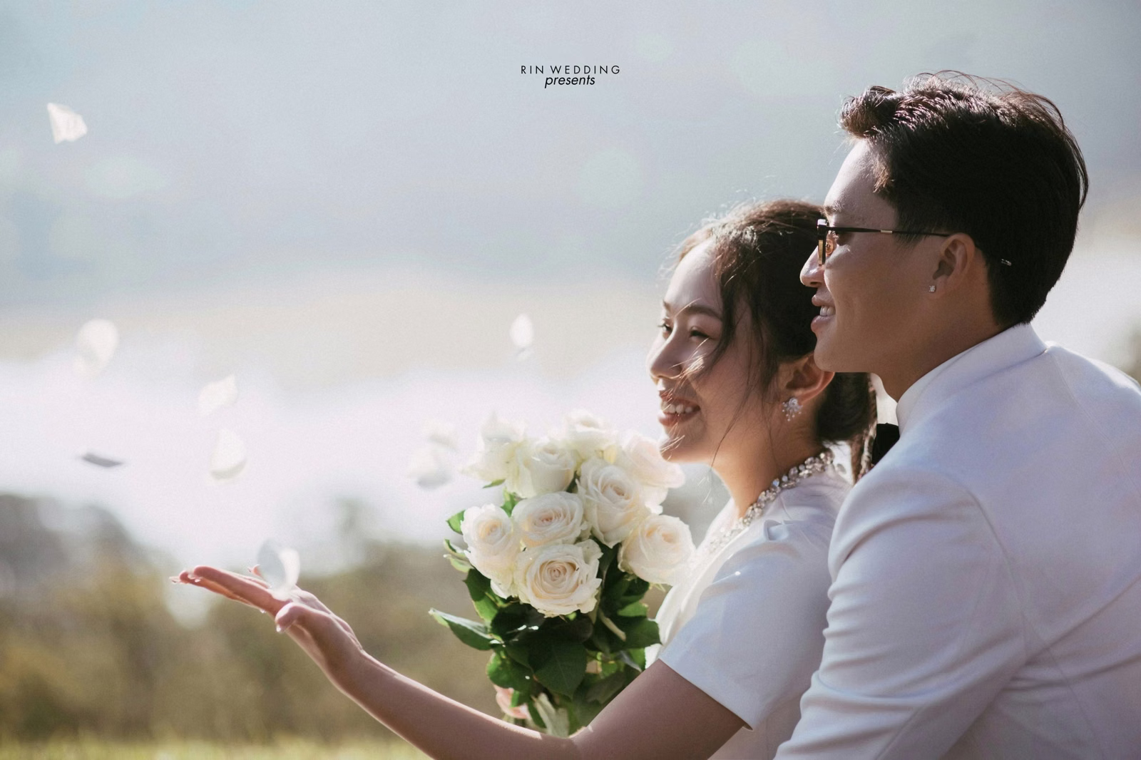 The couple looks toward the sunshine with a white bouquet at Đồi Thông Đà Lạt