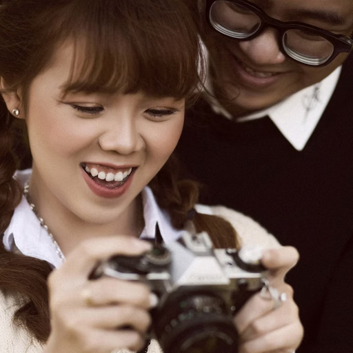 The bride holding a camera beside the groom at Cao Đẳng Sư Phạm Đà Lạt.