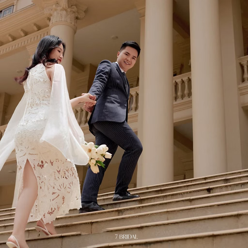 The couple walks hand in hand up the steps at Nhà thờ Don Bosco