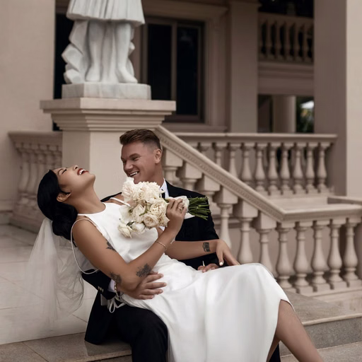 The groom supports the bride as she leans back before a statue and staircase at Don Bosco Đà Lạt.