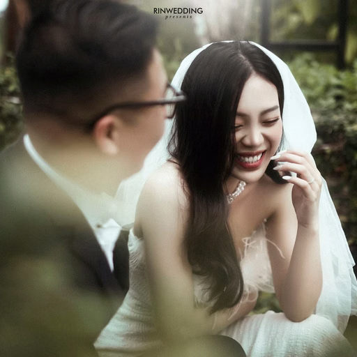 The bride smiling beside the groom in a resort garden.
