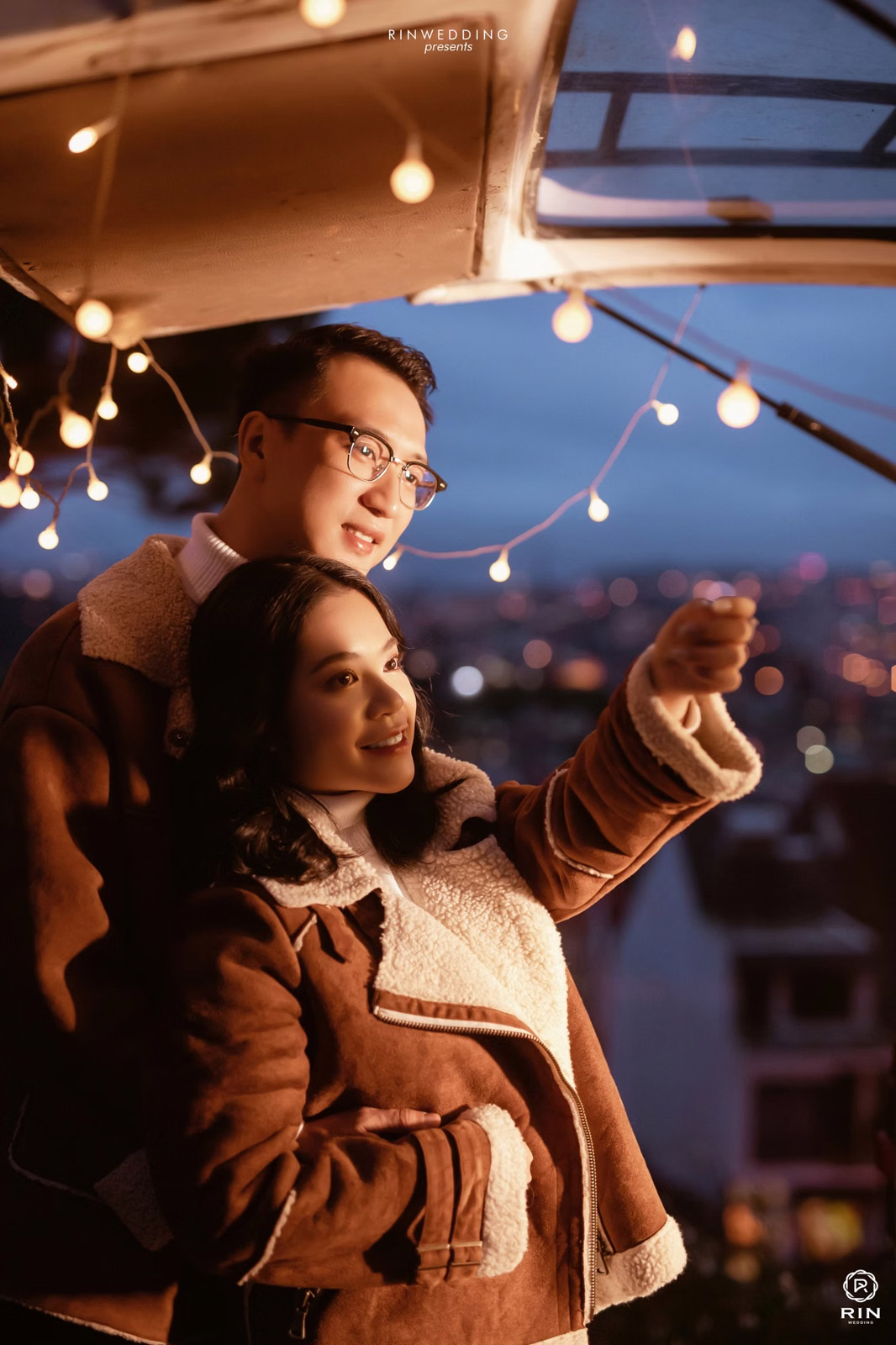 The couple embraces beside a camper van door and looks into the distance.