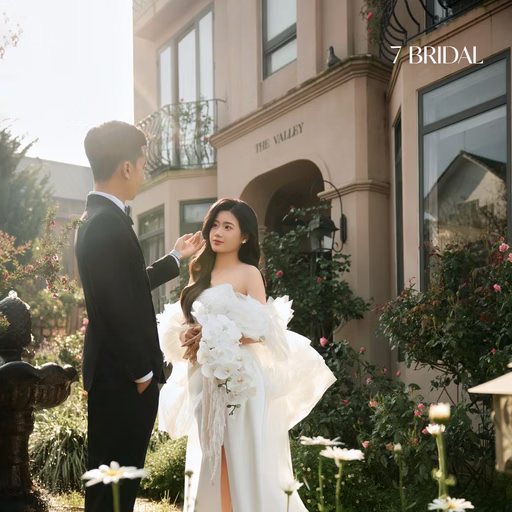 The bride holding flowers beside the groom in a daisy garden at The Nest, Da Lat