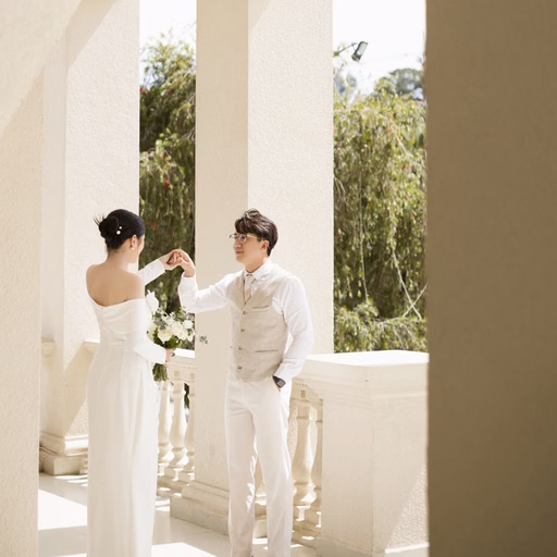 A bride and groom look at each other beside a railing at Nhà thờ Don Bosco