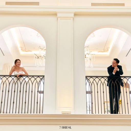 The bride and groom in two separate arched balcony openings.