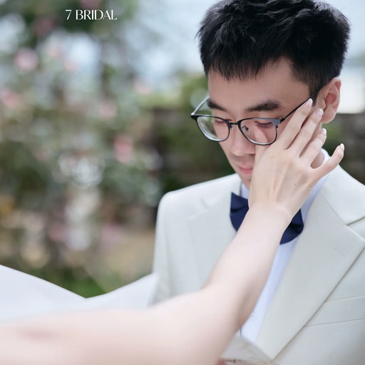 A bride touches the cheek of the groom wearing glasses at The Nest, Đà Lạt