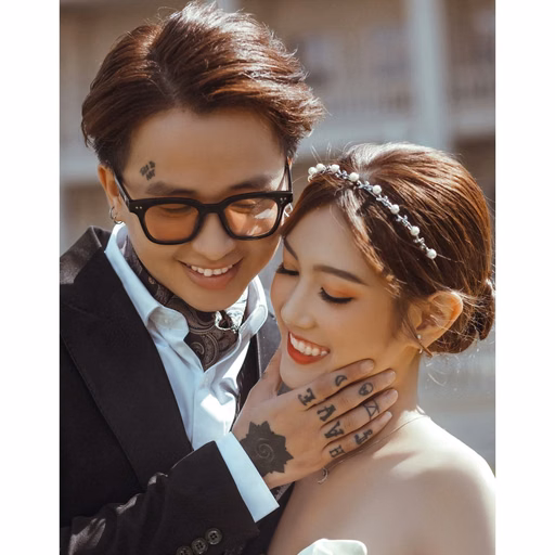 The couple leans close together at Nhà thờ Don Bosco