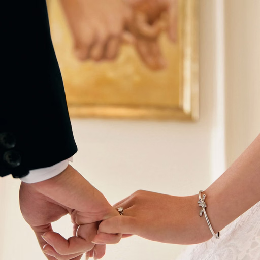 A close-up of the bride and groom holding hands on their wedding photoshoot day.