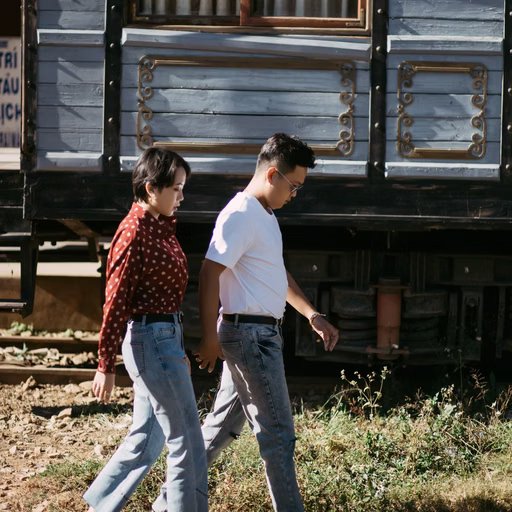 The couple strolling beside a green carriage at Ga Đà Lạt.