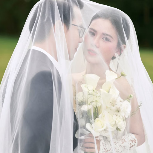 The couple looking at each other beneath a wedding veil at Cây Thông Cô Đơn, Da Lat