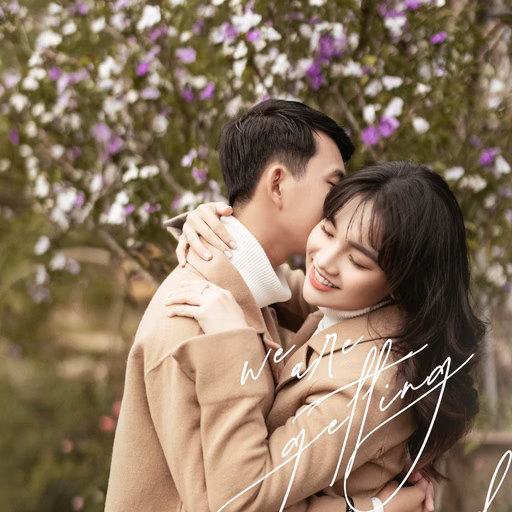 A couple embraces beneath purple blossoms at Ga Đà Lạt.
