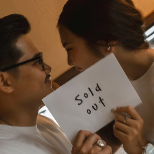 The couple in white T-shirts hold a Sold out sign at a Đà Lạt café.
