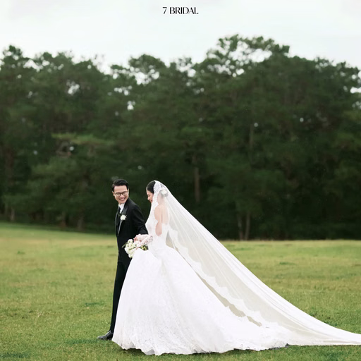 The couple stands before pine trees with a white train spread out at Cây Thông Cô Đơn, Đà Lạt