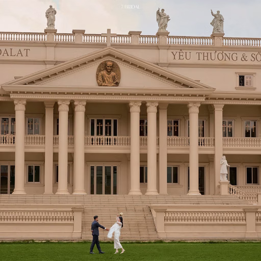 The bride and groom walking before the columns of Nhà thờ Don Bosco