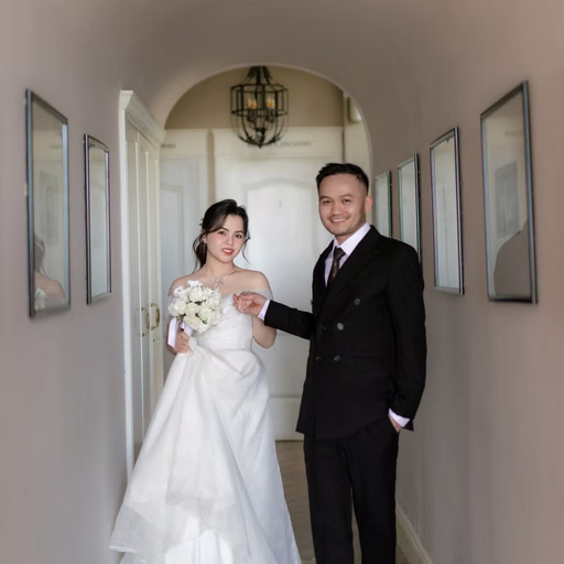 The couple walk through a corridor with framed artwork at The Nest, Đà Lạt