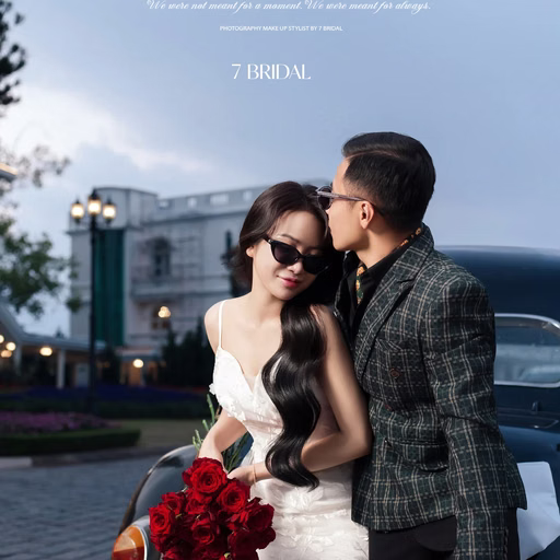 The groom kissing the forehead of the bride wearing sunglasses outside a hotel.