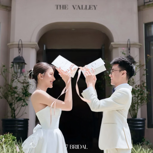 The couple touches two books together before an arched doorway at The Nest, Đà Lạt