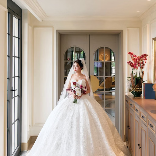 The bride in a full wedding gown in a bright room.