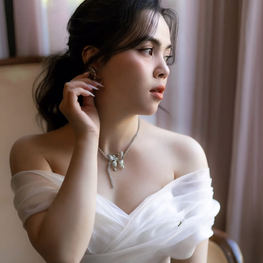 A bride holds flowers, looks out a window and touches her hair at The Nest, Đà Lạt