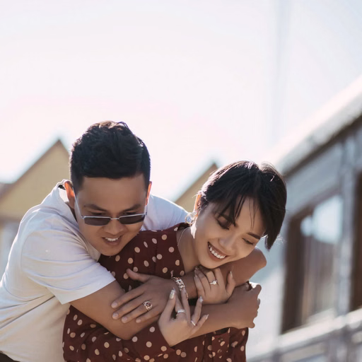 The groom carries the laughing bride on his back beside a carriage at Ga Đà Lạt.