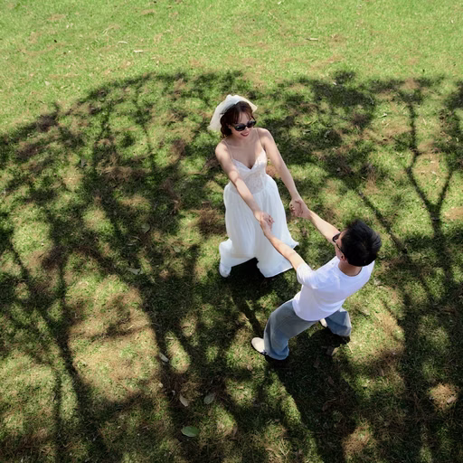 Overhead view of the couple holding hands in a pine tree’s shadow at Cây Thông Cô Đơn, Da Lat