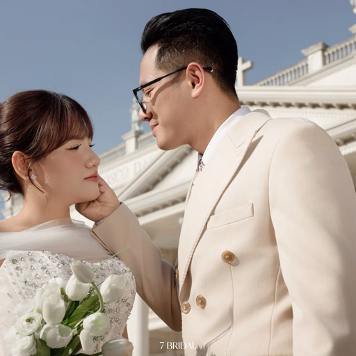 The groom touching the bride's cheek before Nhà thờ Don Bosco