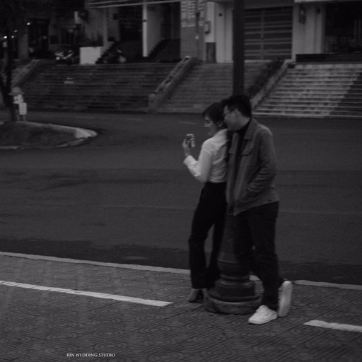 Black-and-white photograph of the couple beside a Da Lat street.