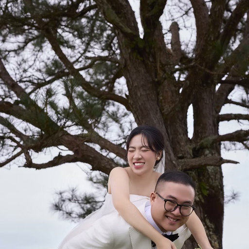 The groom carries the bride on his back beside a pine trunk at Cây Thông Cô Đơn, Đà Lạt