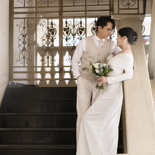 The bride and groom touching foreheads beside the stairs at Nhà thờ Don Bosco