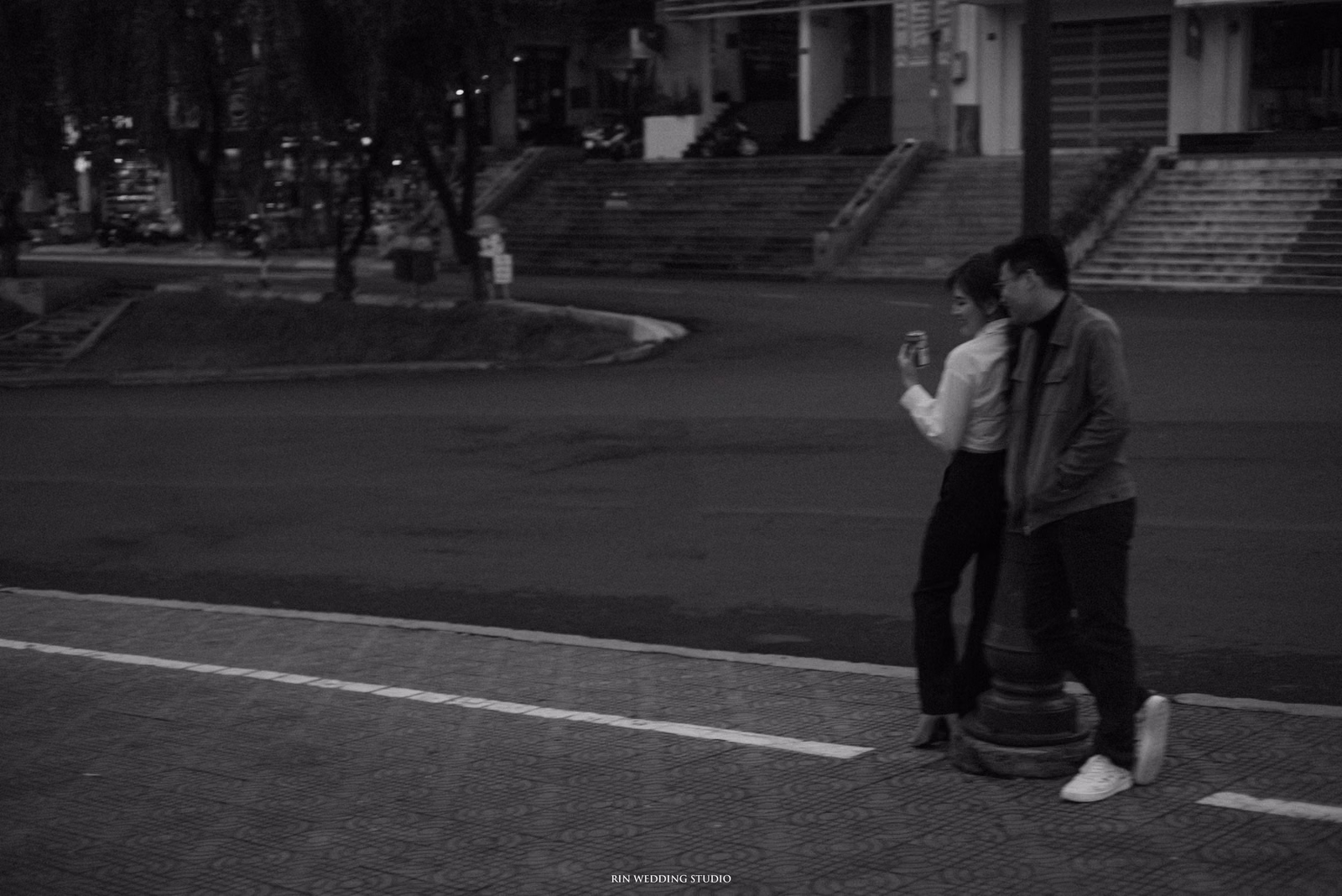 Black-and-white photograph of the couple beside a Da Lat street.