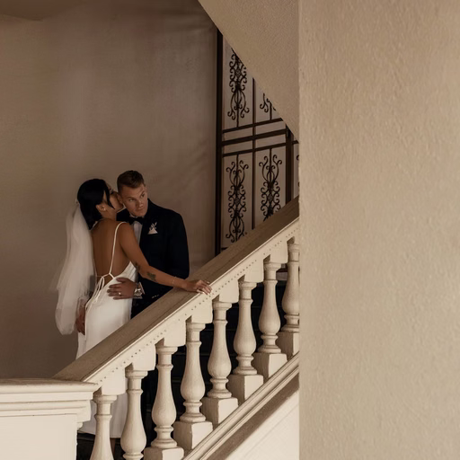 The bride and groom lean close beside the stair railing at Don Bosco Đà Lạt.